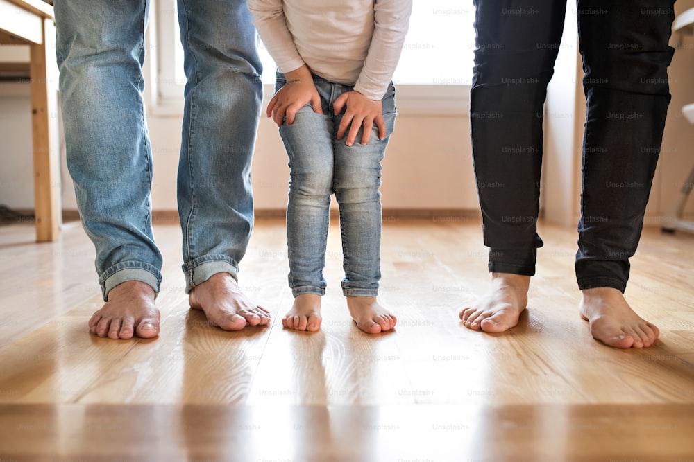 Hermosa familia joven. Primer plano de los pies descalzos de la madre, el padre y la hija.