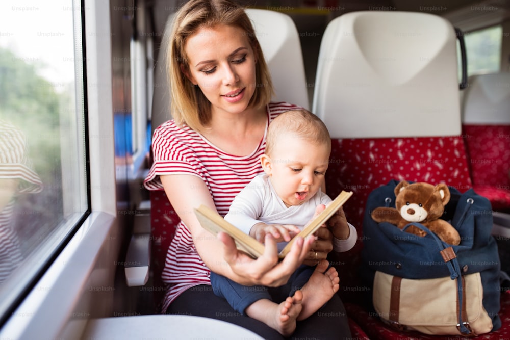 기차로 아기와 함께 여행하는 젊은 어머니. 아름다운 여자와 그녀의 아들의 철도 여행.