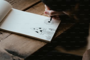 une personne écrivant sur un morceau de papier avec un stylo