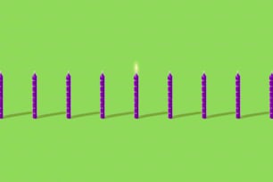 una fila di candele sedute in cima a una superficie verde