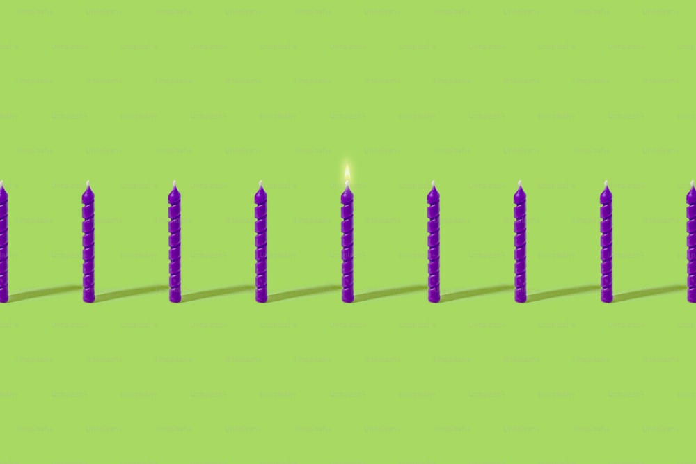 a row of candles sitting on top of a green surface