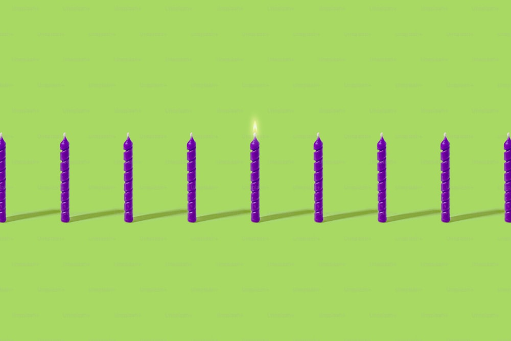 Una fila de velas sentadas encima de una superficie verde