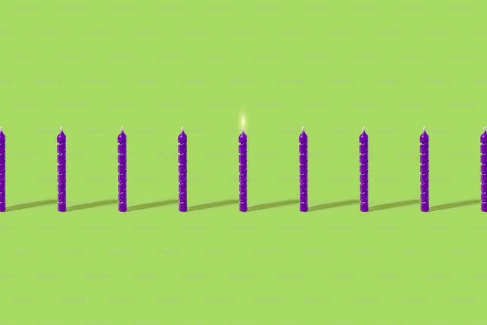 eine Reihe von Kerzen, die auf einer grünen Oberfläche sitzen