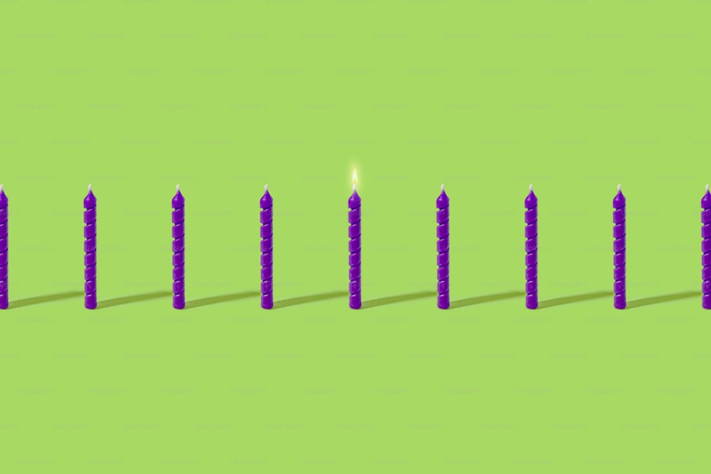 a row of candles sitting on top of a green surface