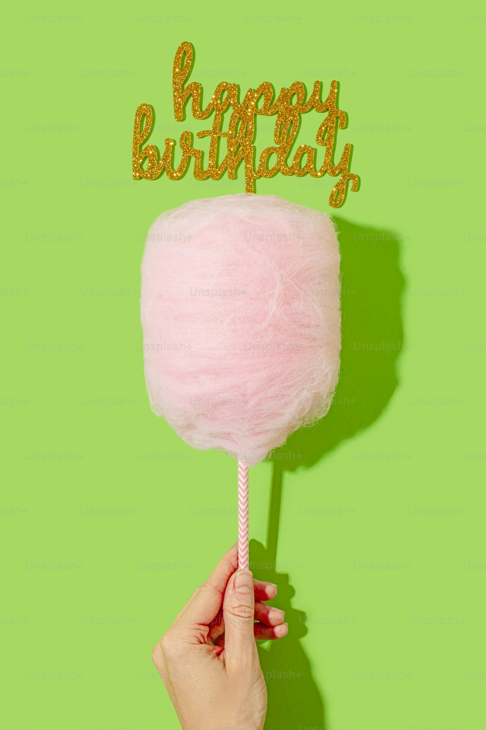 a person holding a pink lollipop with a happy birthday sign on it