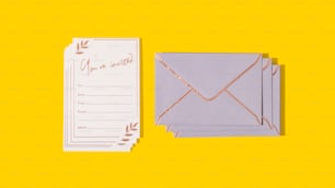 a set of four envelopes and a card on a yellow background