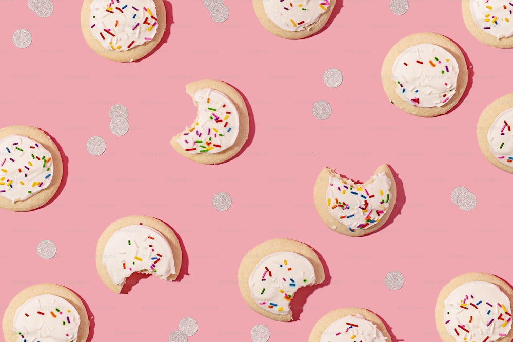 a pink background with lots of cookies and sprinkles