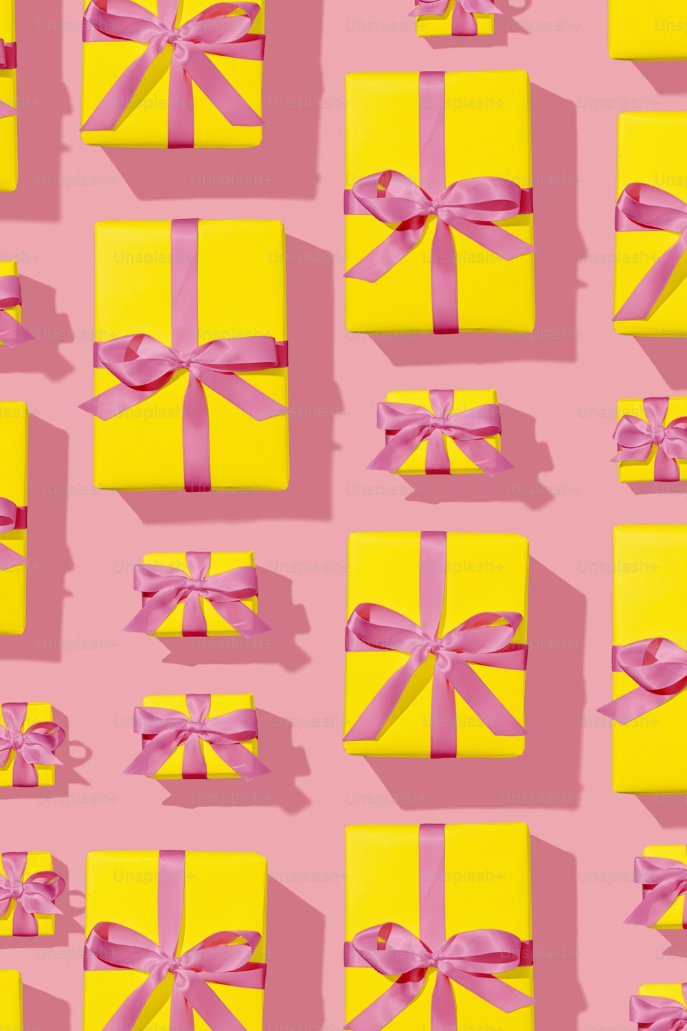 a yellow box with a pink bow on a pink background