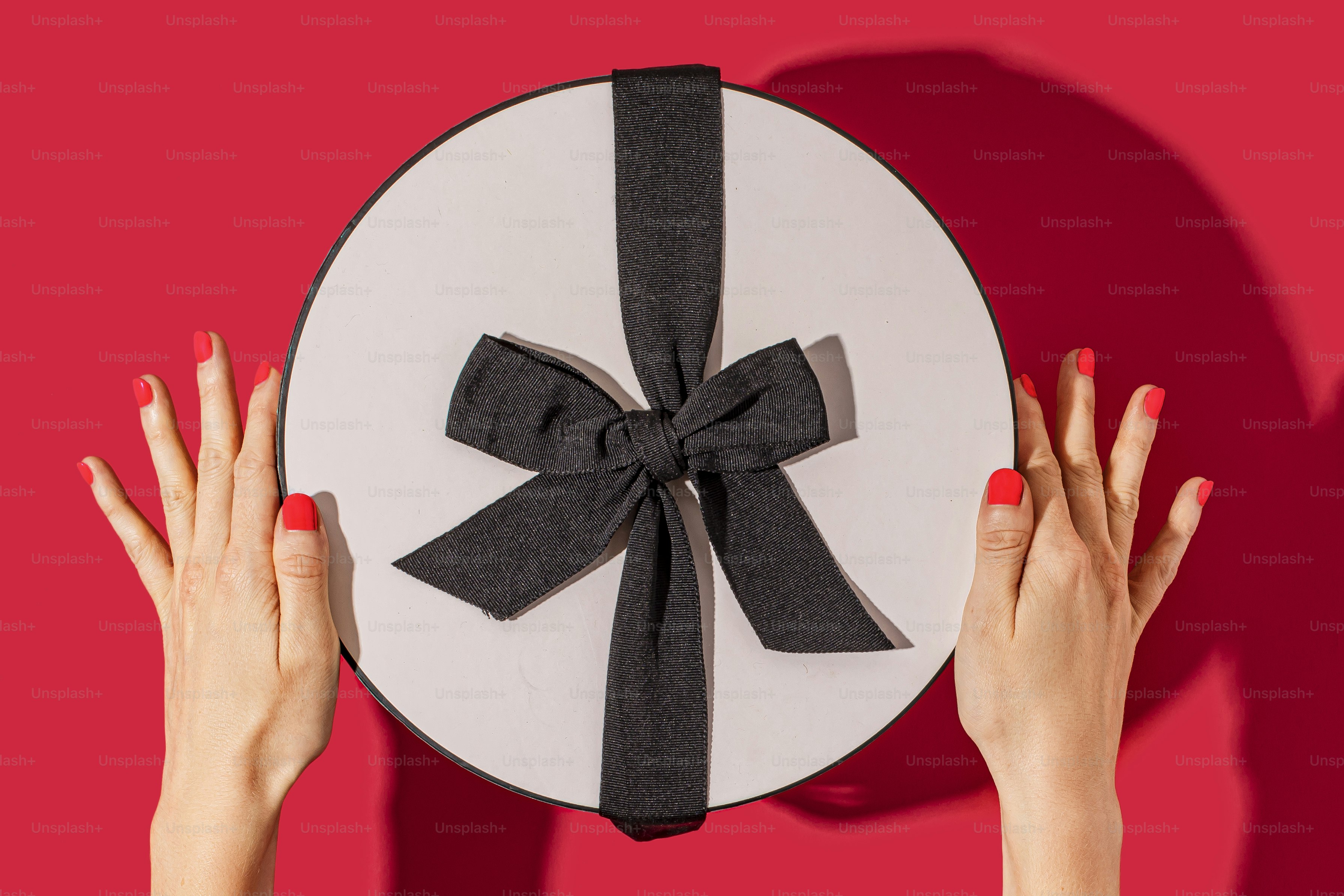 a woman's hands holding a paper plate with a bow on it
