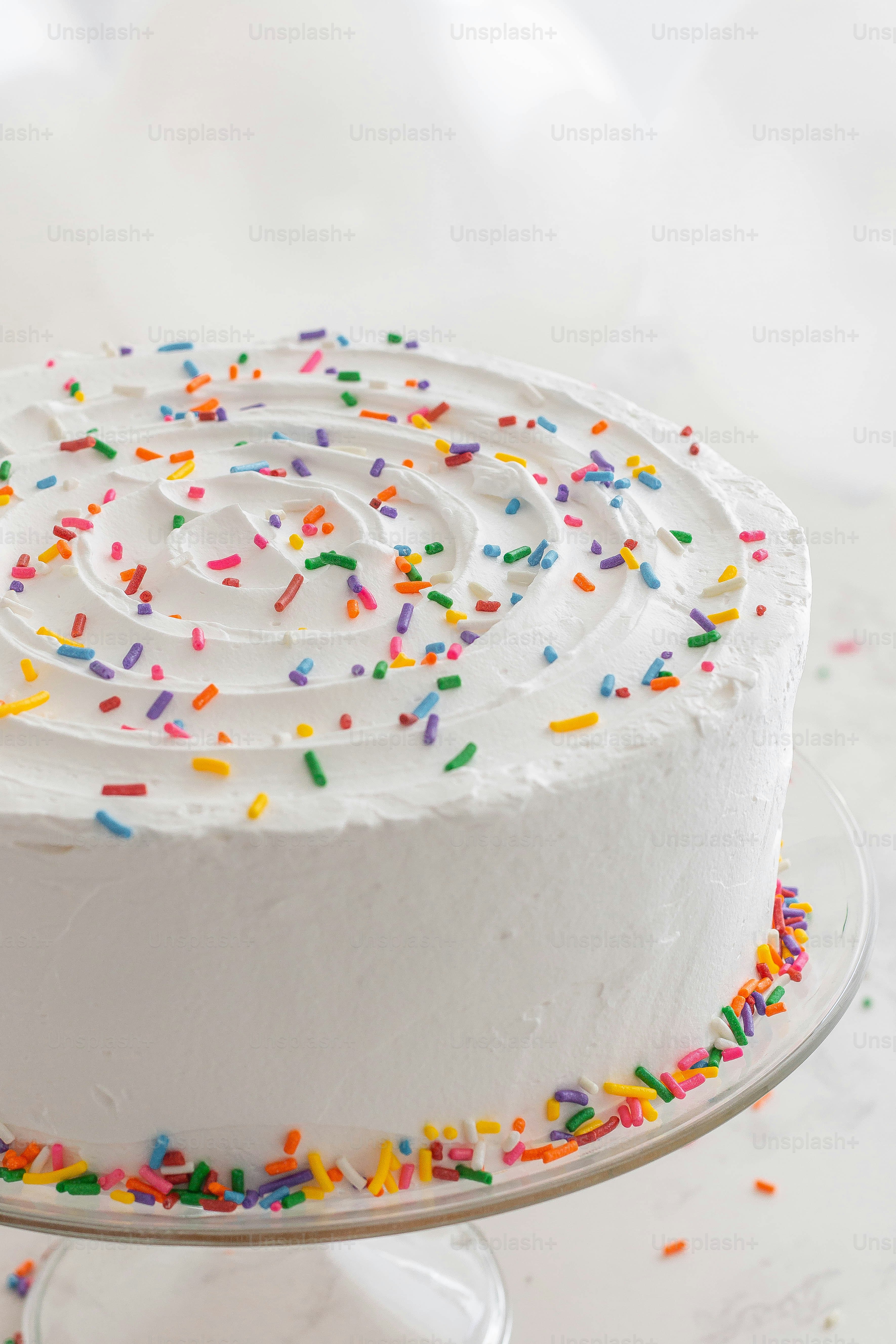 A cake with white frosting and sprinkles photo – White cake Image on ...