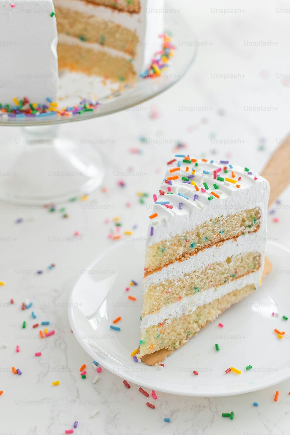 a slice of cake on a plate with sprinkles