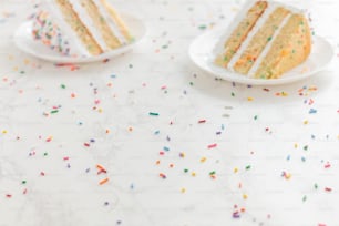 una mesa blanca cubierta con dos rebanadas de pastel