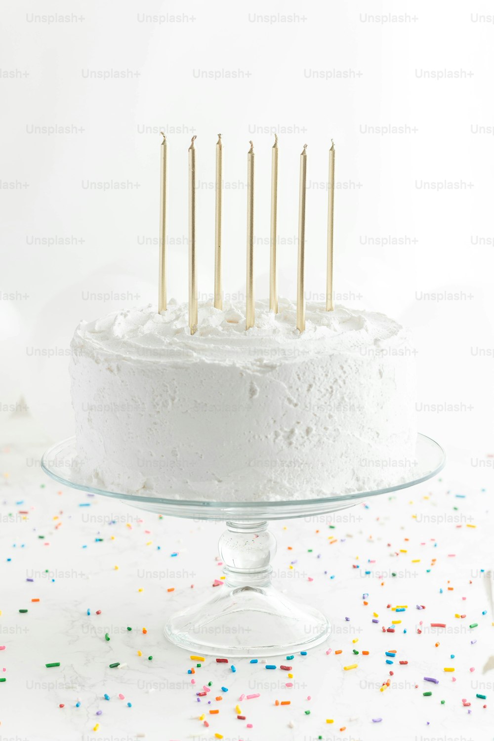 a cake with white frosting and gold candles