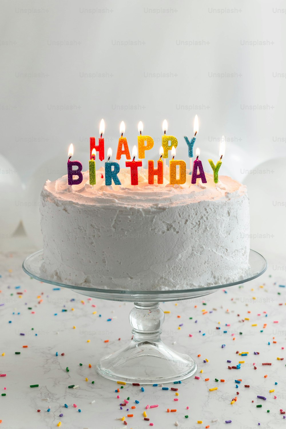 Un pastel de cumpleaños con velas encendidas sentado sobre una mesa