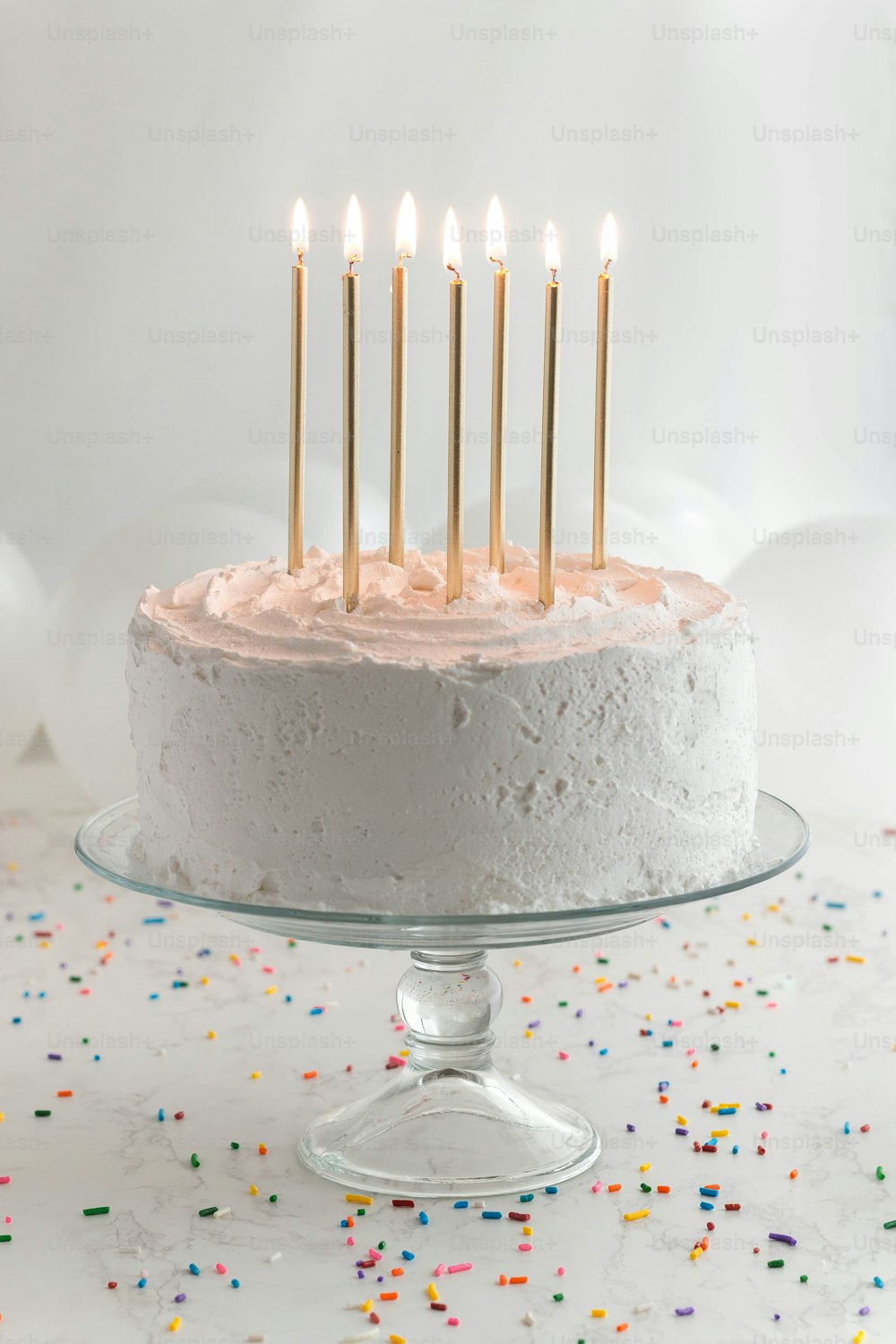 하얀 설탕 프로스팅과 촛불이 켜진 생일 케이크