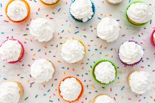 un tas de cupcakes avec glaçage blanc et saupoudrage