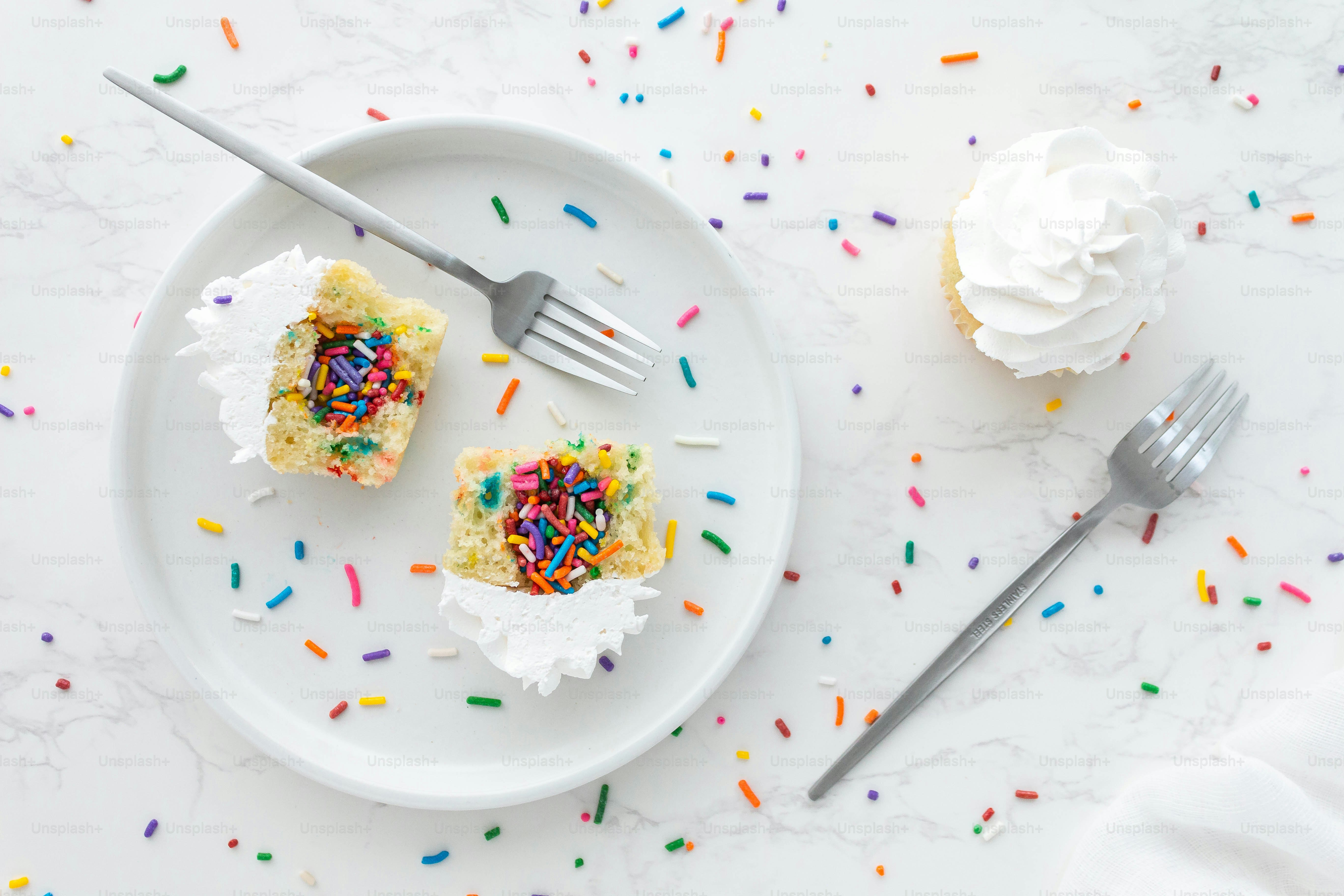 a white plate topped with cupcakes covered in sprinkles