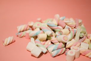 a pile of candy canes on a pink background