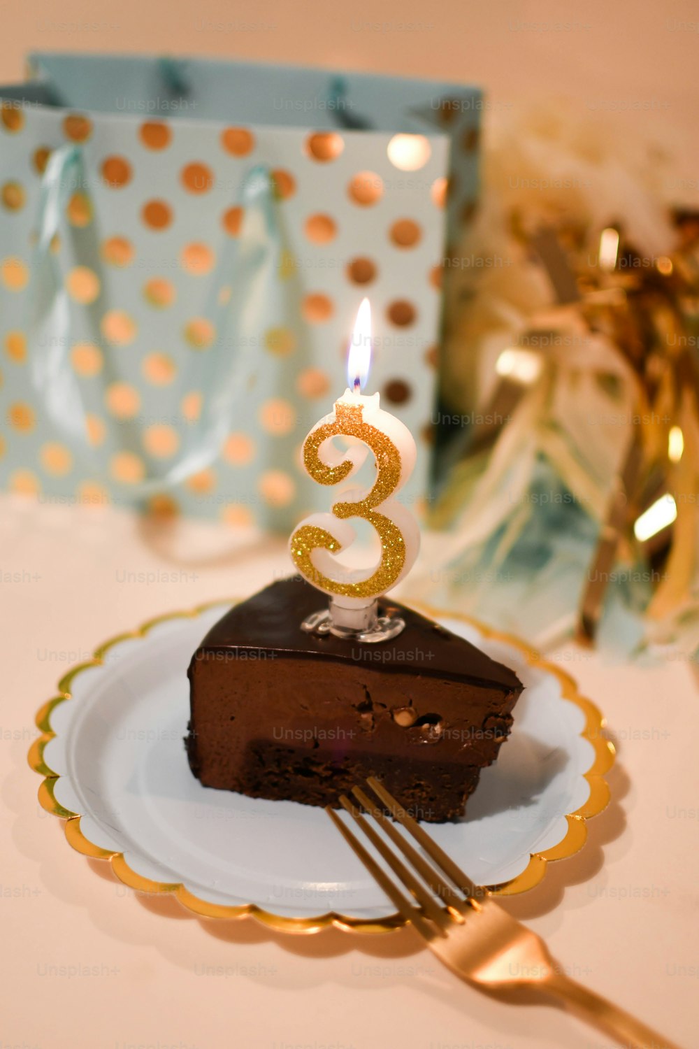 a piece of chocolate cake on a plate with a candle