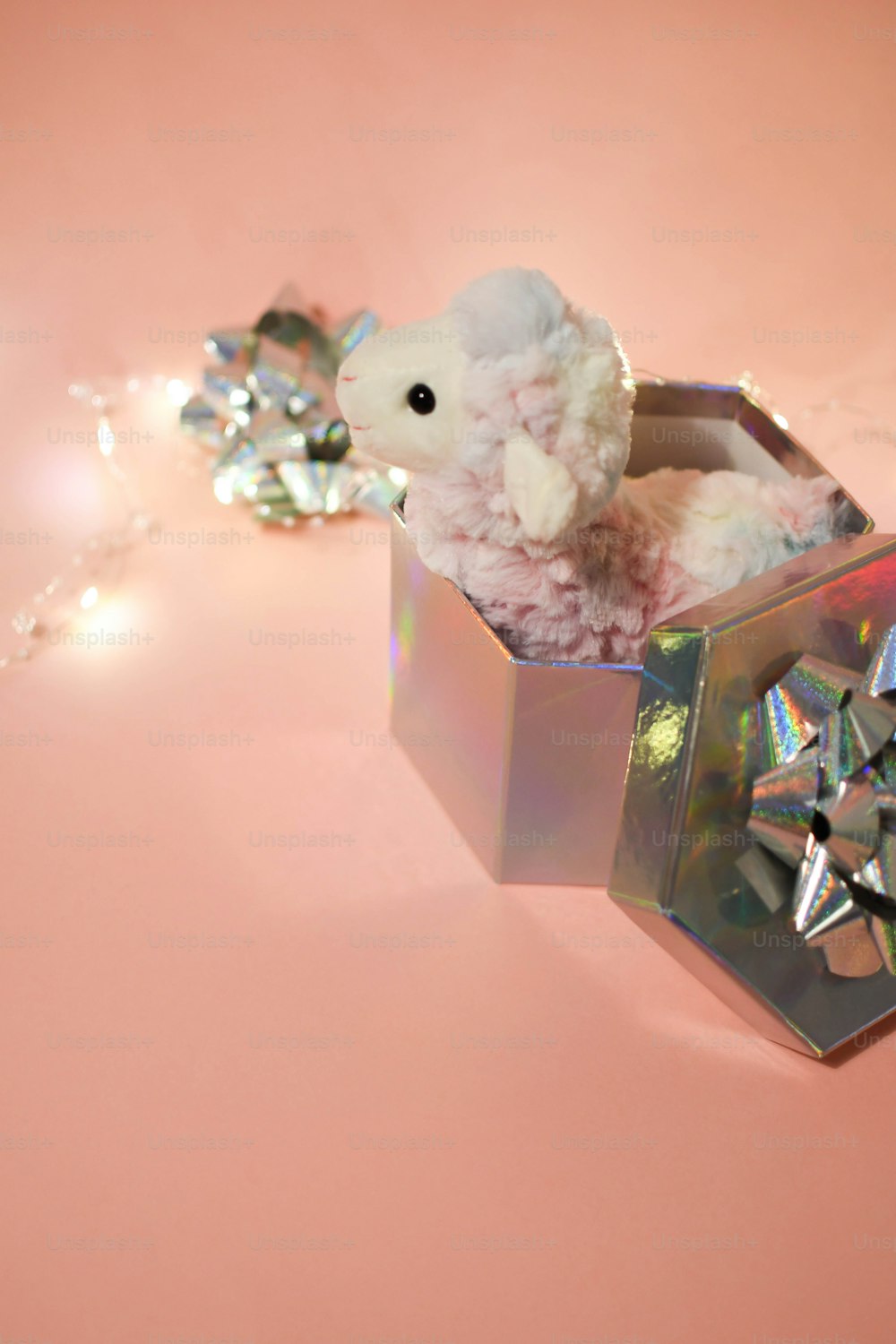 a small white teddy bear sitting inside of a box