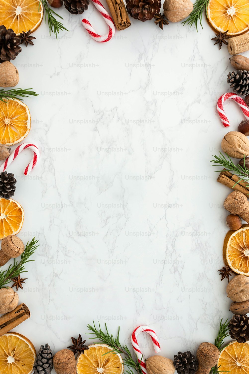 a white table topped with oranges, pine cones and candy canes