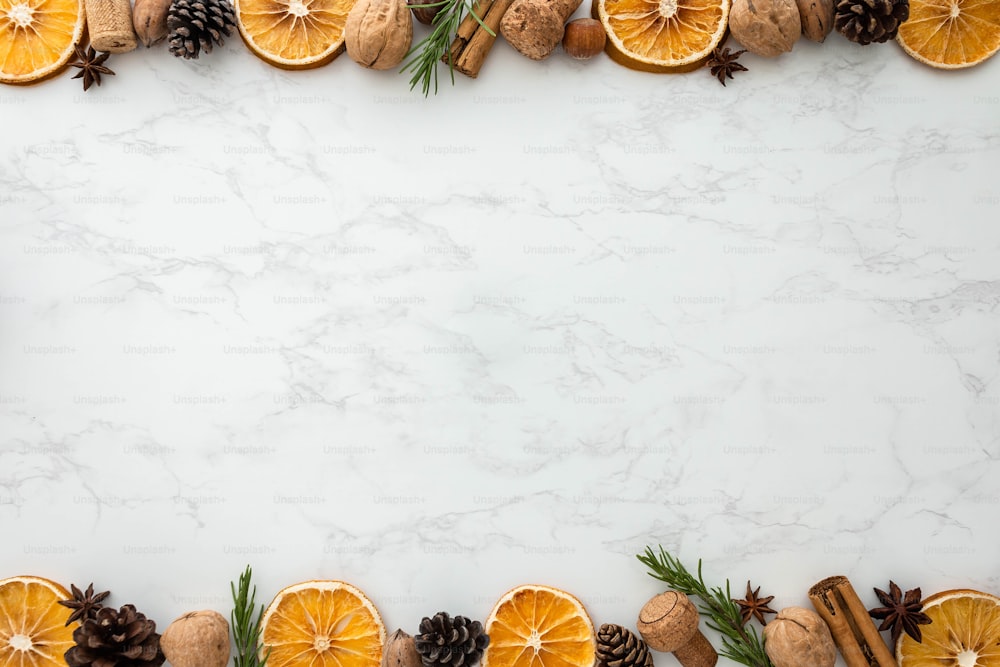 a white marble background with orange slices and pine cones