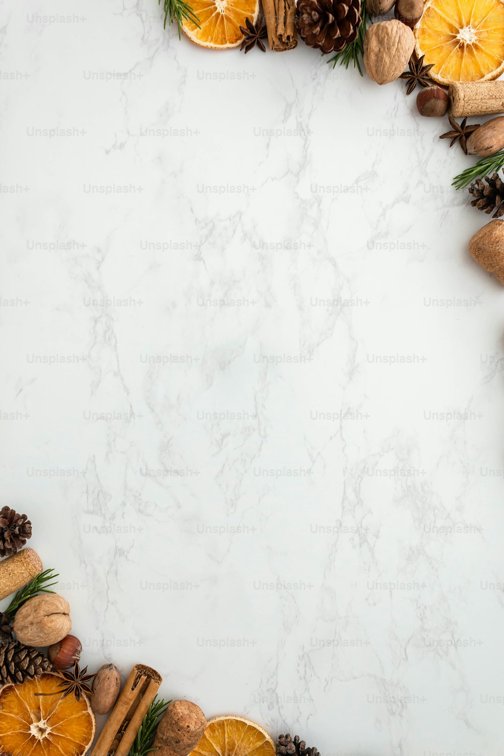 a white marble background with pine cones, oranges and cinnamons