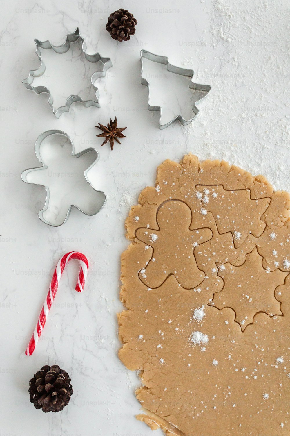 a cookie cutter, cookie cookies, and candy cane on a table