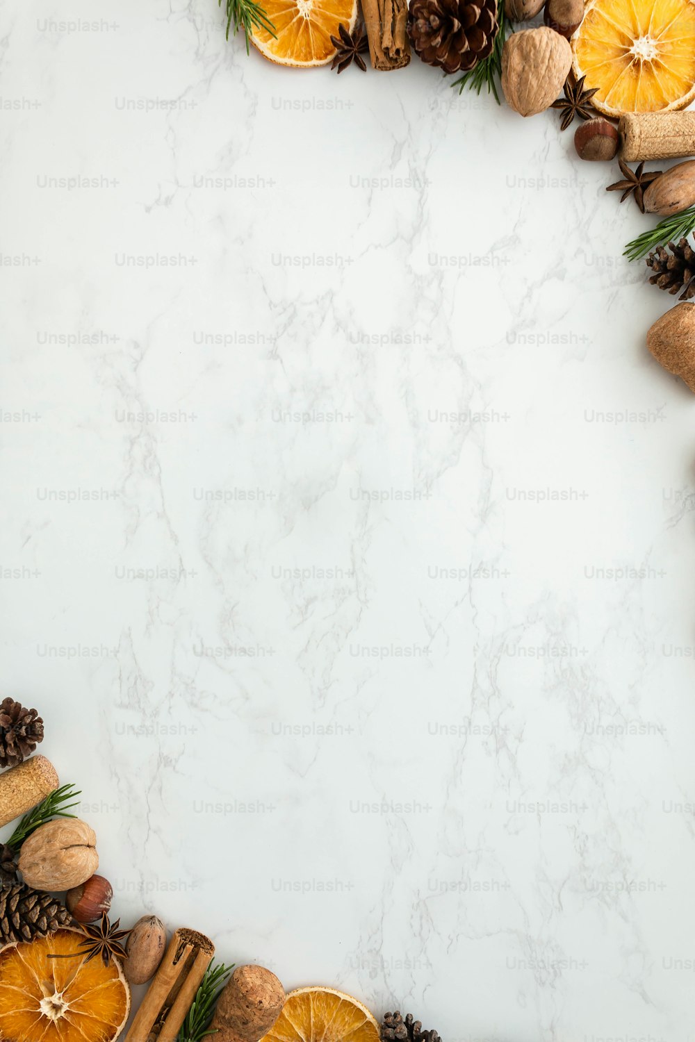 a white marble background with oranges and pine cones