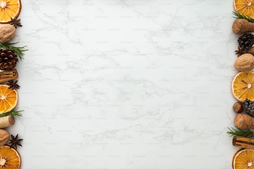 a white marble background with oranges and pine cones