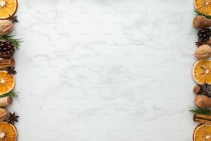 uno sfondo di marmo bianco con arance, pigne e noci