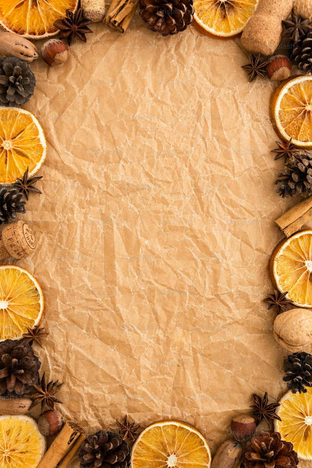 a piece of paper surrounded by oranges and pine cones