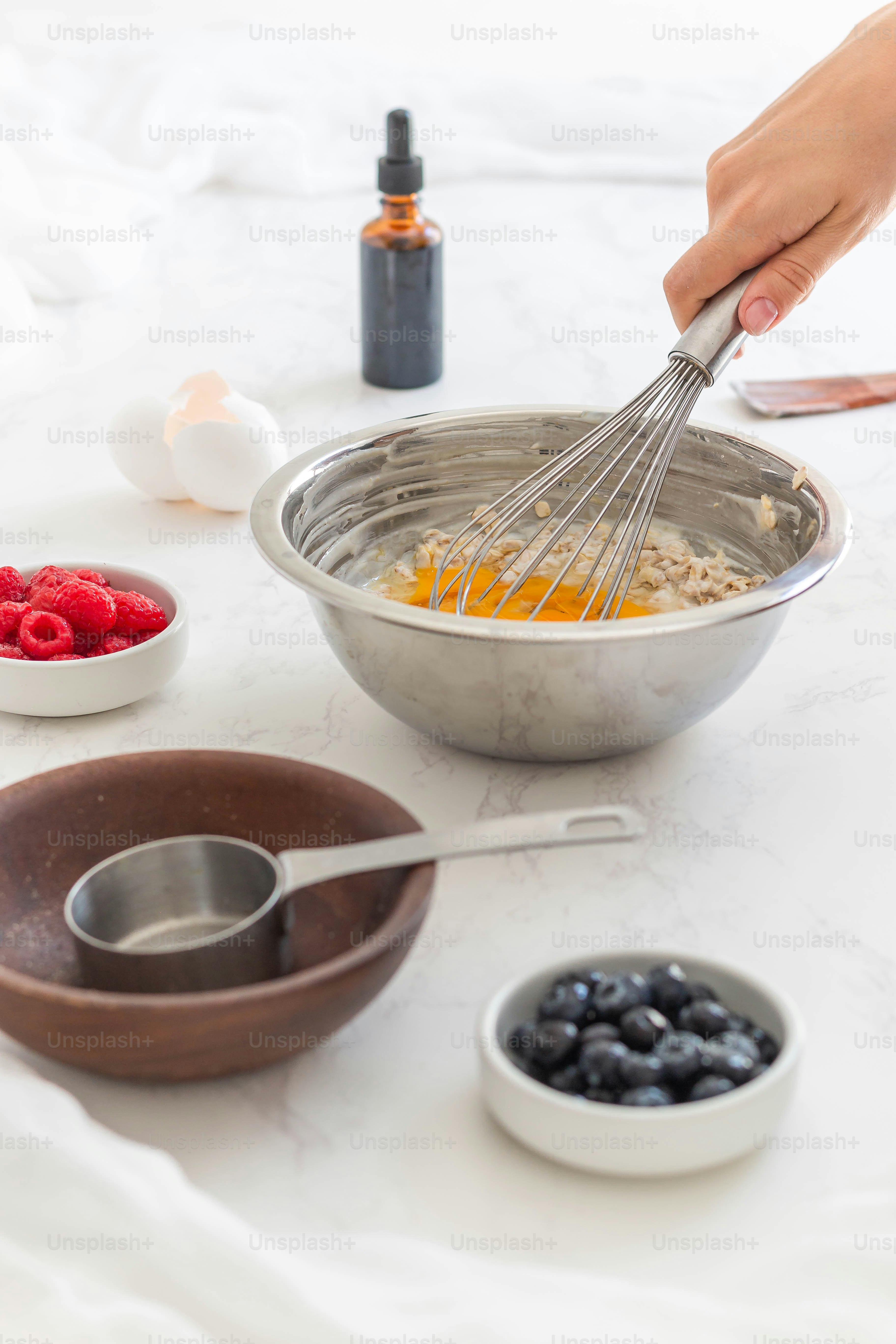 una persona che sbatte le uova in una ciotola con una frusta