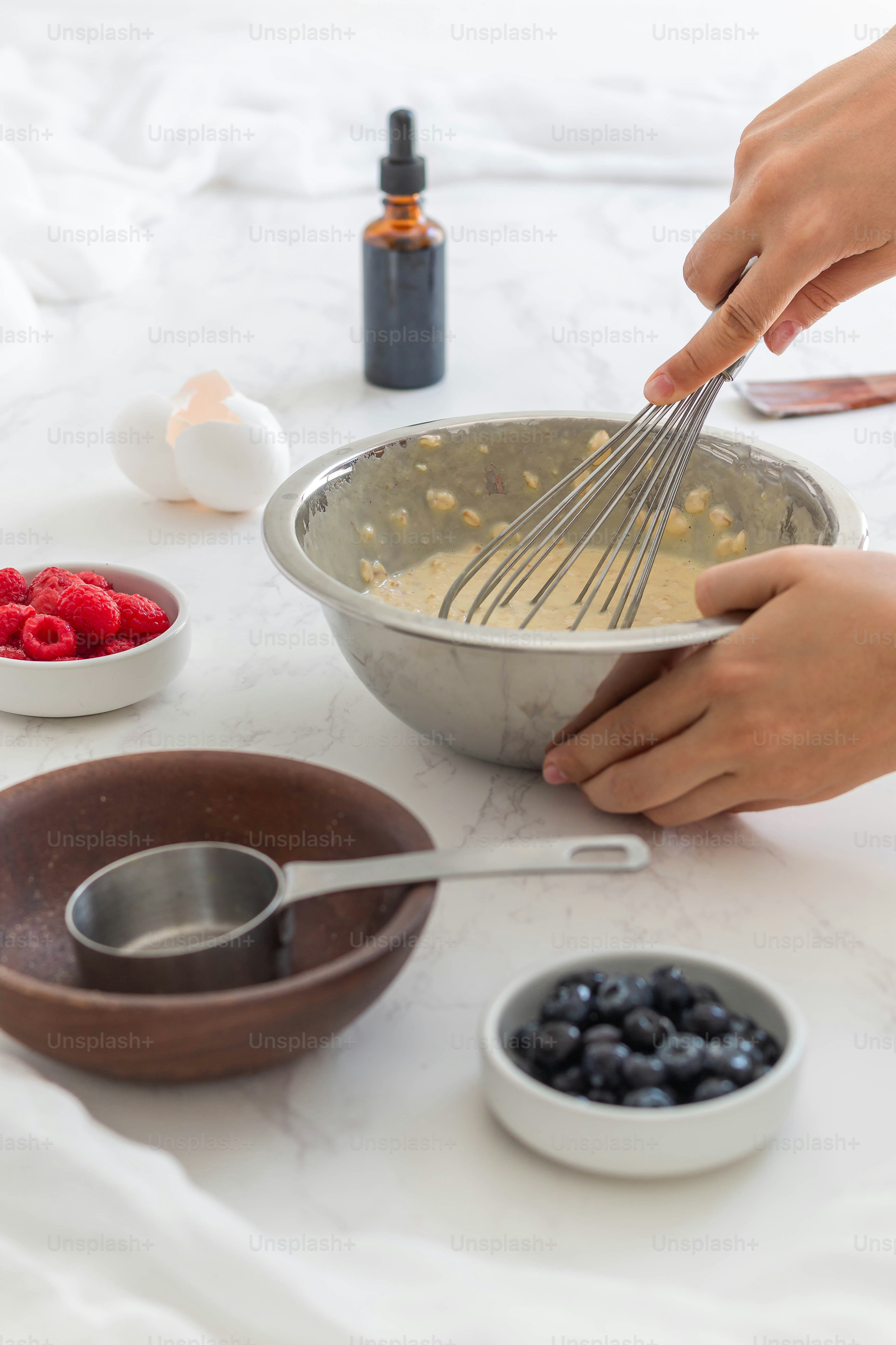 A person mixing ingredients in a bowl with a whisk photo Breakfast