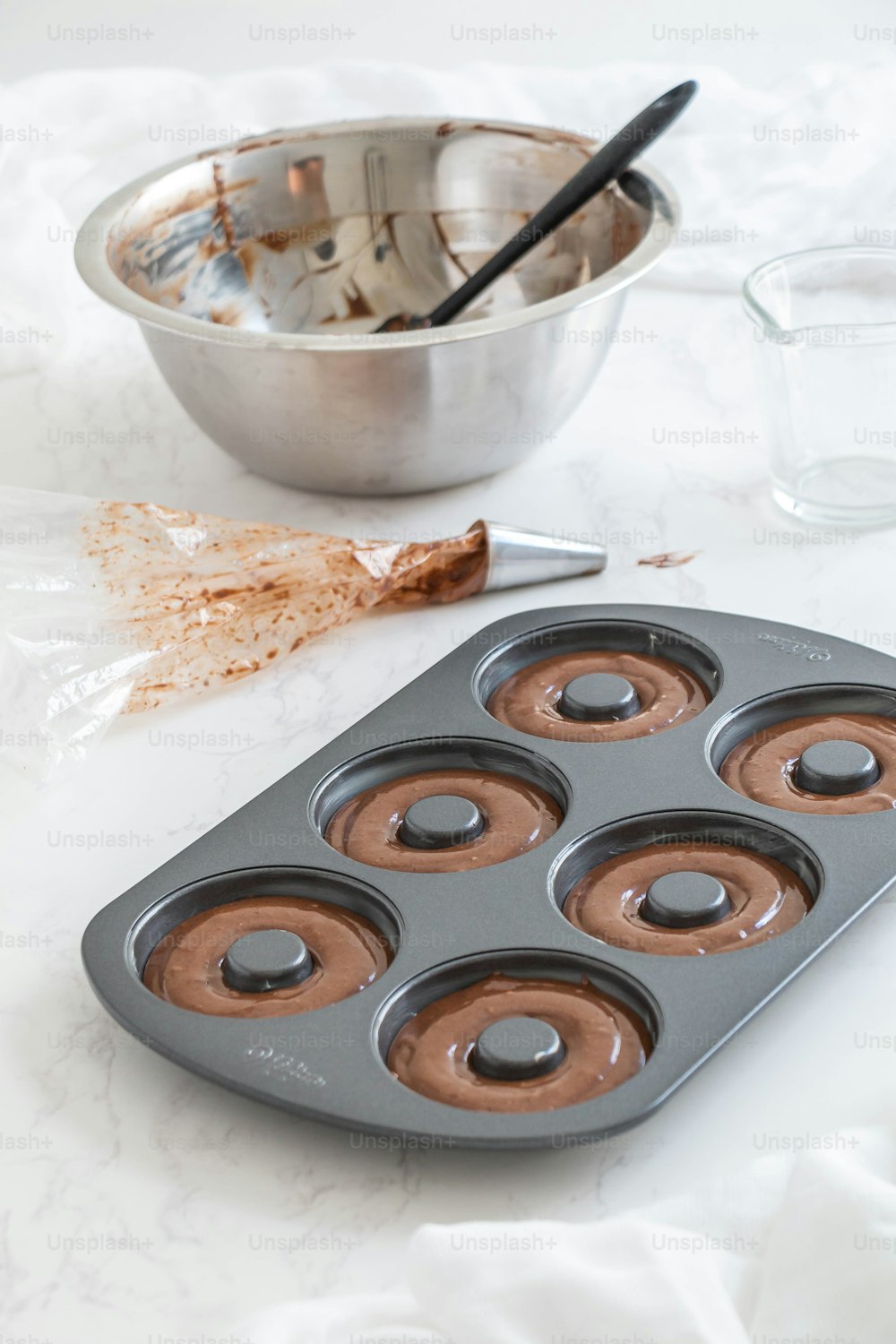 a muffin pan with chocolate frosting in it