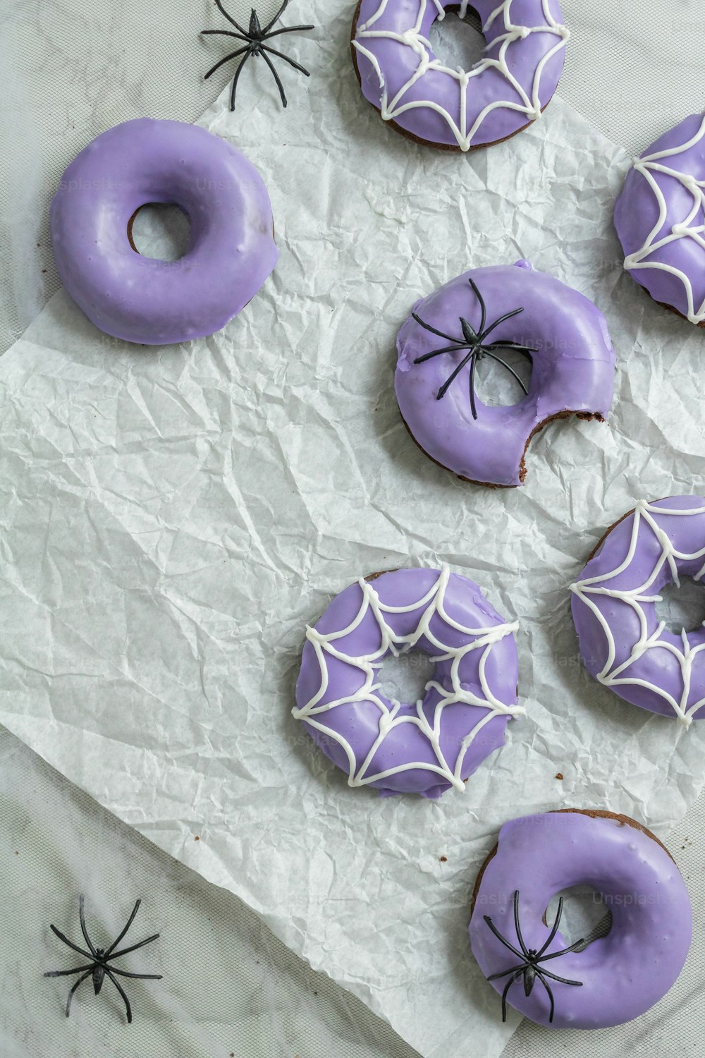 a table topped with purple donuts covered in icing