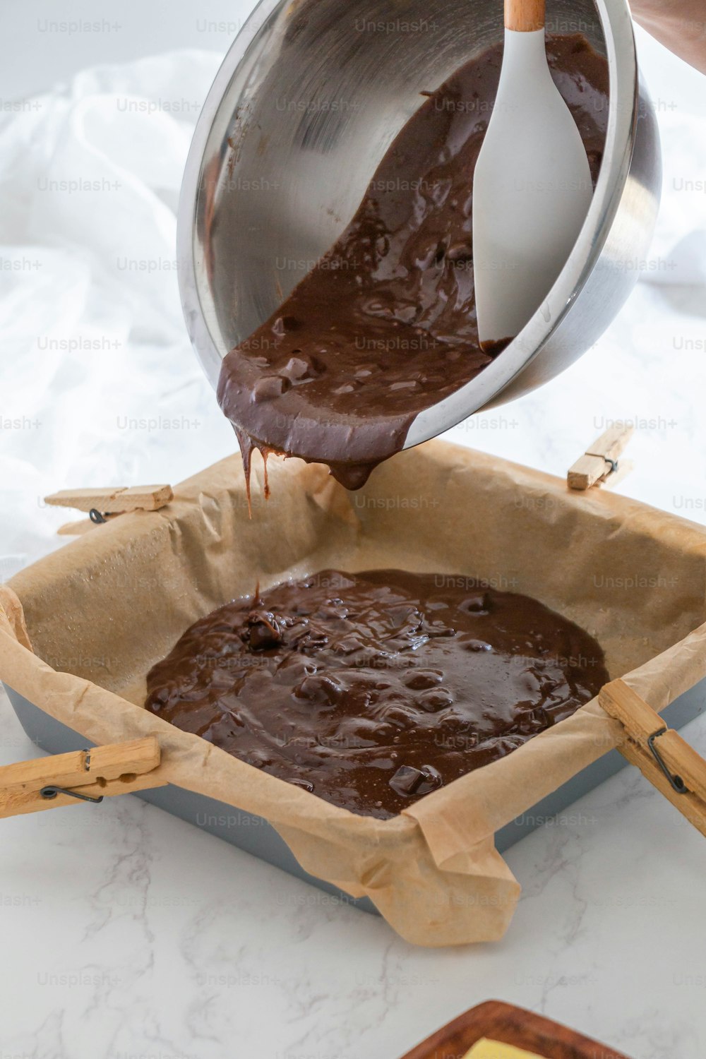 a person pouring chocolate into a pan