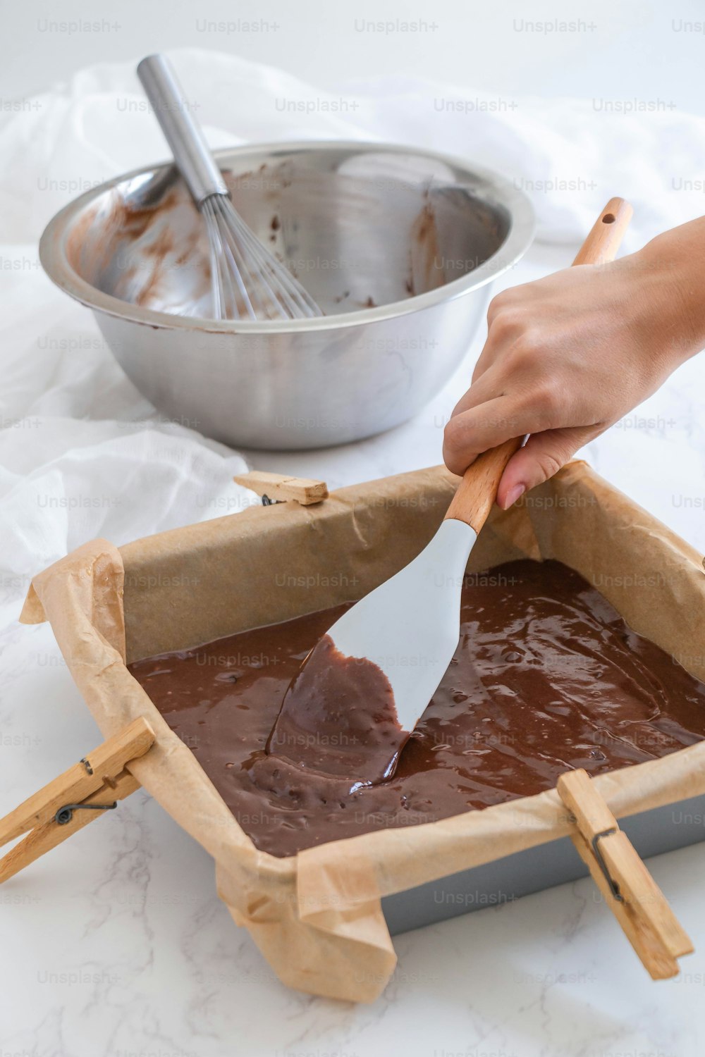 a person scooping chocolate out of a pan