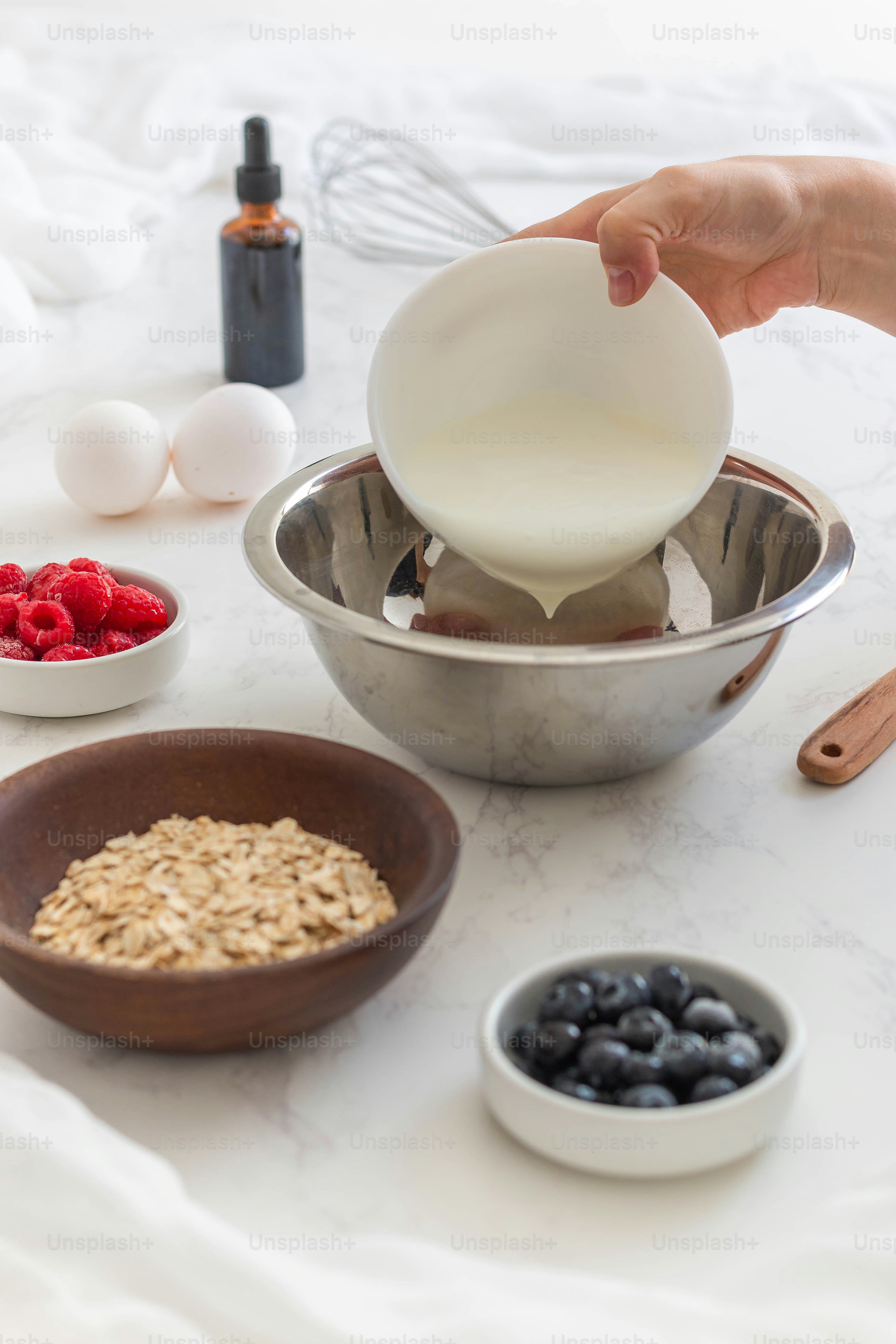 a person pouring milk into a bowl of oatmeal