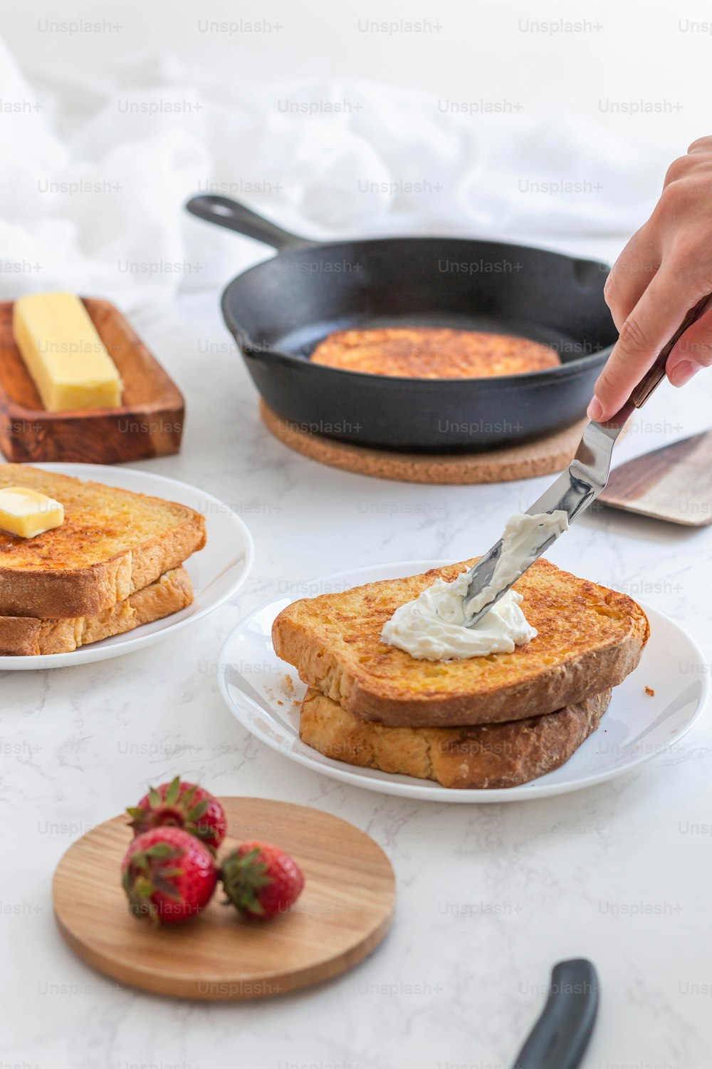 a person spreading butter on a piece of toast