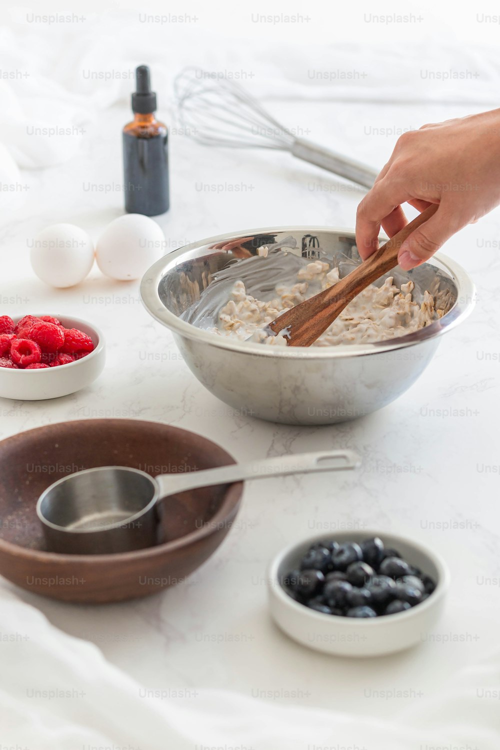 a bowl of oatmeal with berries and a whisk
