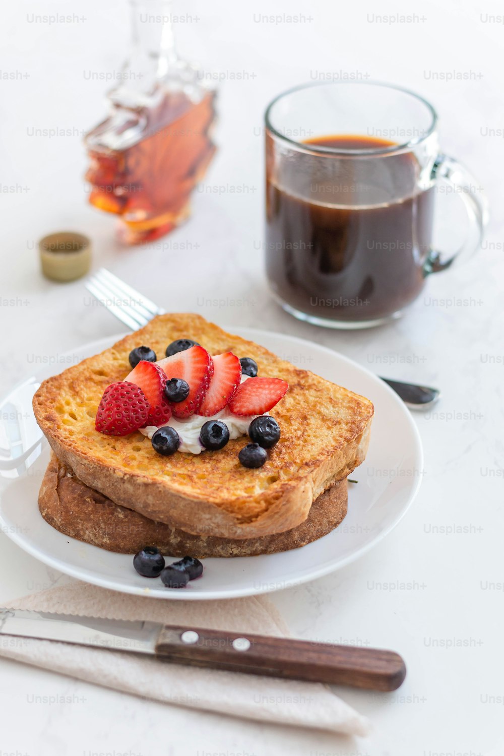 une assiette blanche garnie de pain perdu et de baies