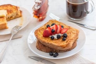a plate of french toast with fruit on top