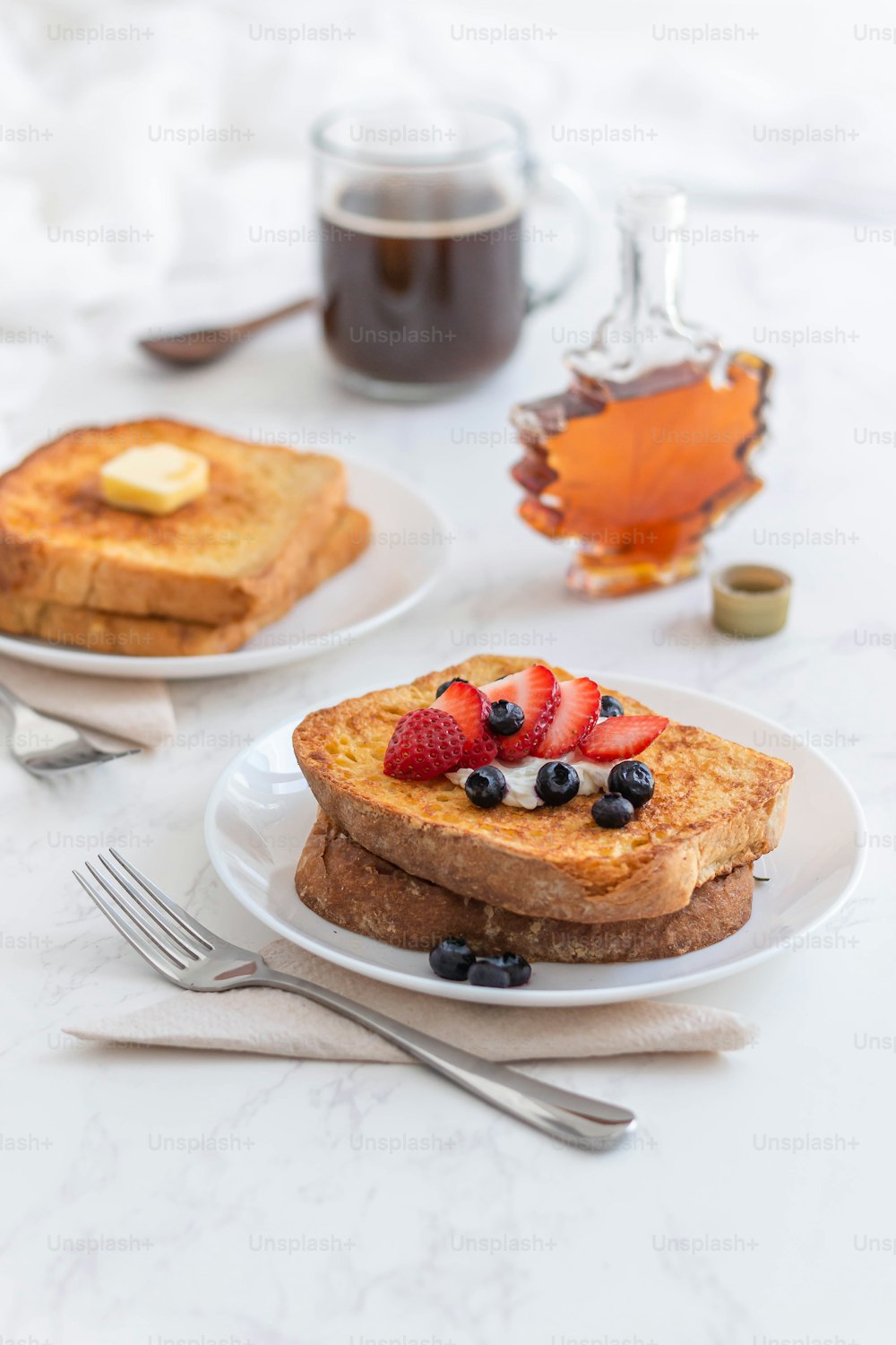 deux assiettes avec du pain perdu et des baies