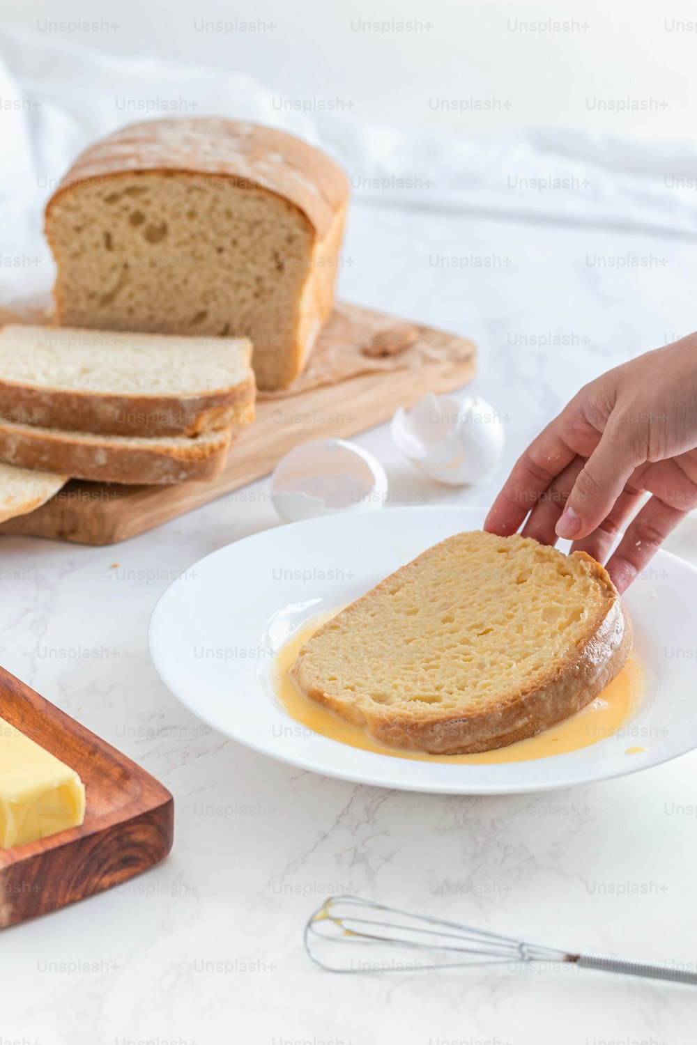 Eine Person streicht Butter auf ein Stück Brot