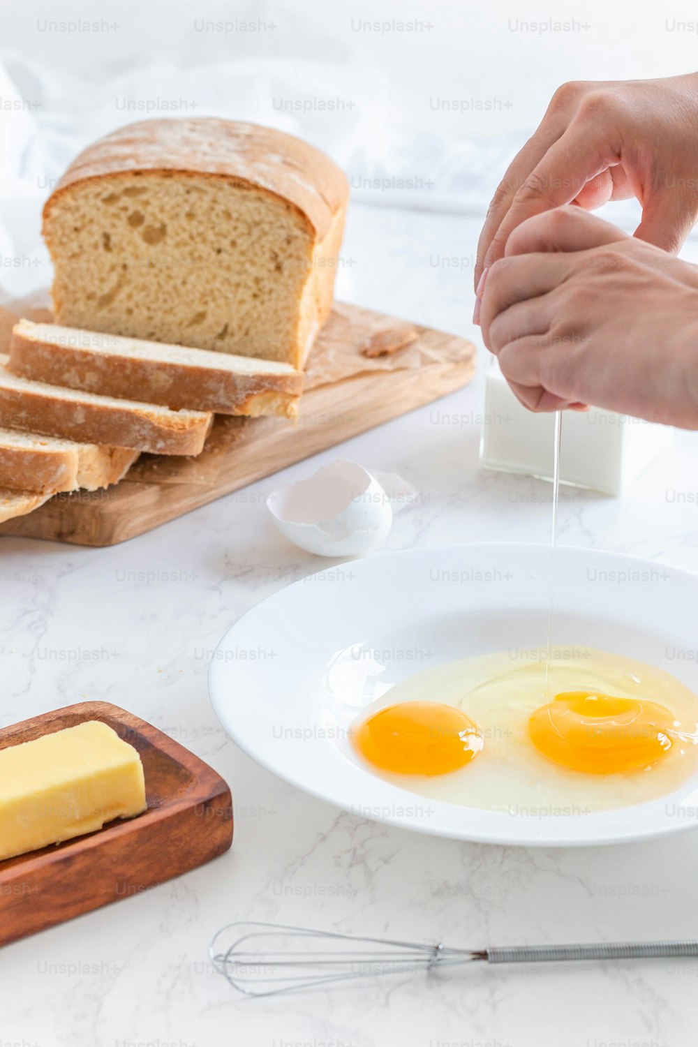 a person holding a piece of bread over a plate of eggs