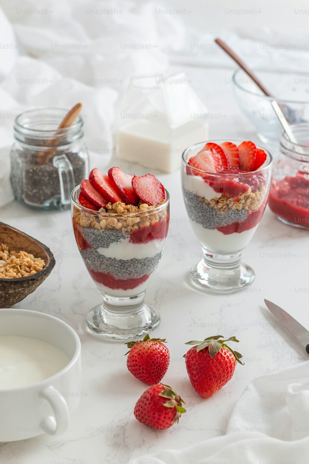 a table topped with bowls of food and a bowl of strawberries