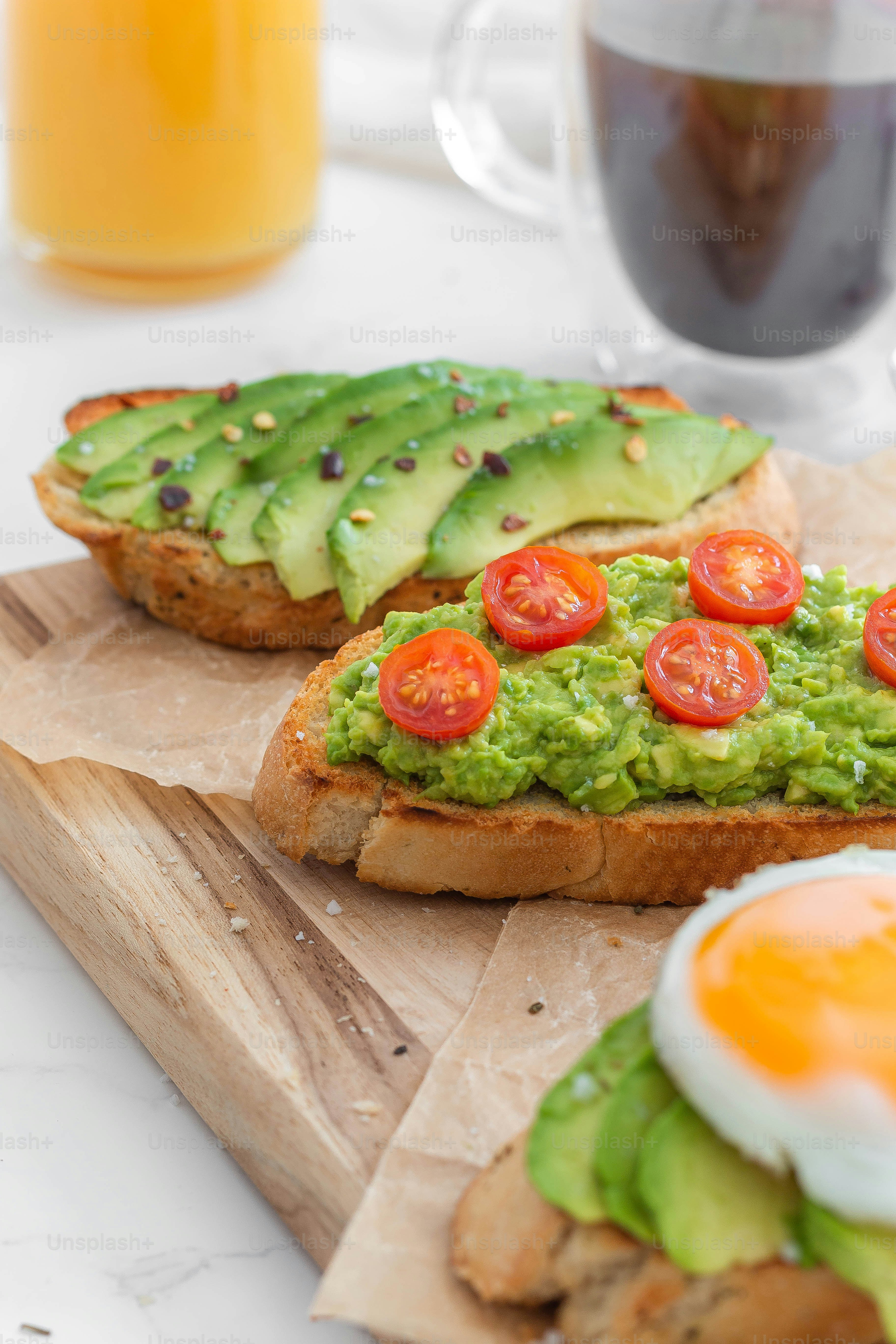two pieces of bread with avocado and tomatoes on them