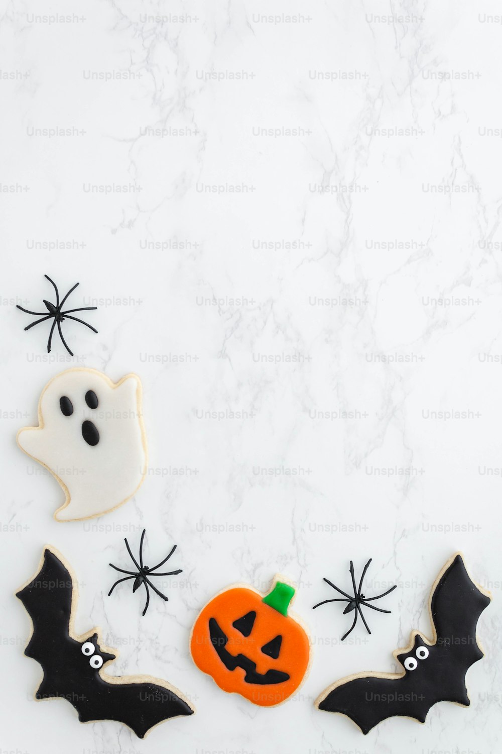 Halloween-Kekse mit Zuckerguss und gruseligen Fledermäusen verziert