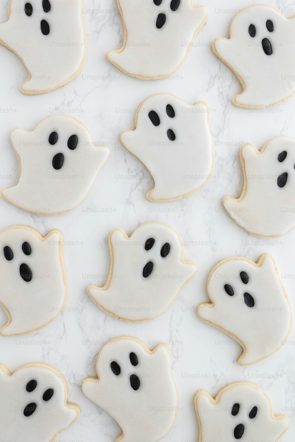 a bunch of cookies that have been decorated to look like ghost faces